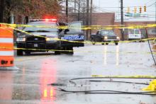 Downed power lines on wet asphalt, caution tape, Cleveland Police cruiser